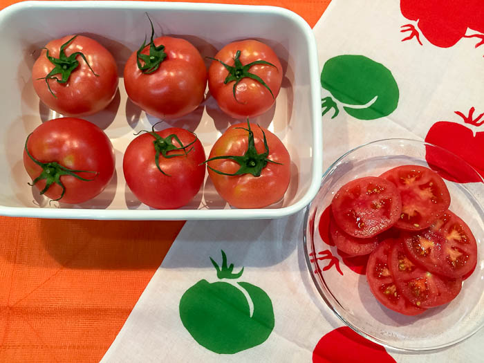 ガラスのお皿にのせたスライストマトと野田琺瑯レクタングルに入れた丸ごとトマト
